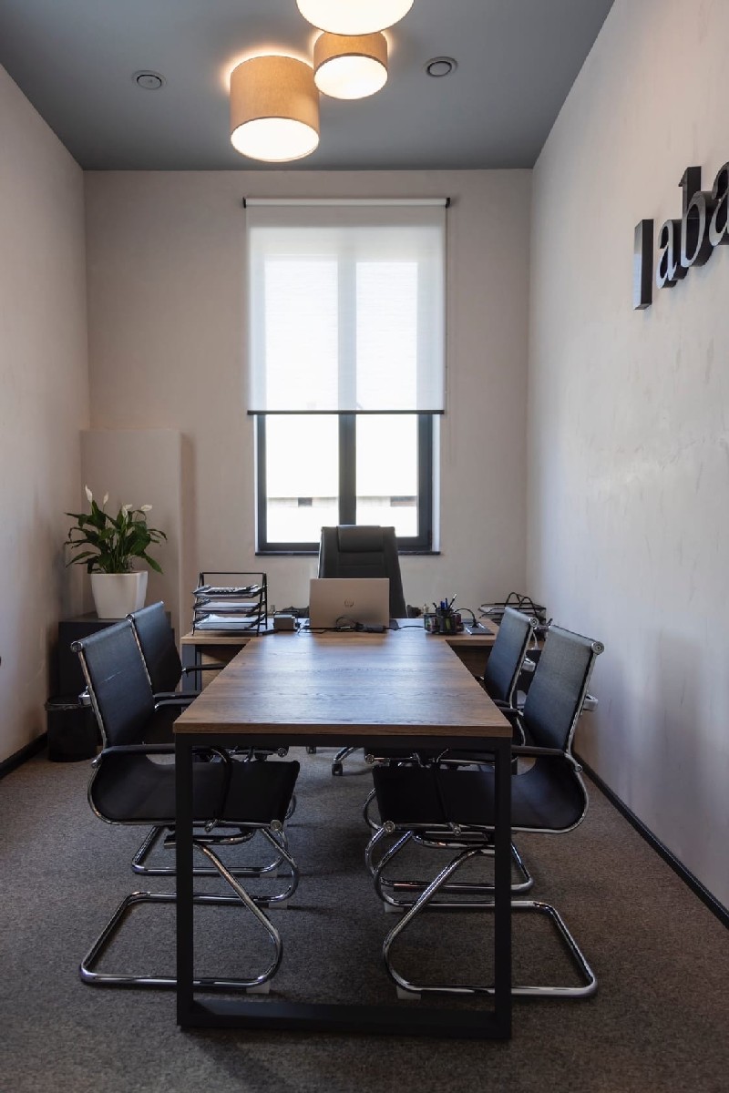 Серый потолок и круглые светильники в офисной переговорной